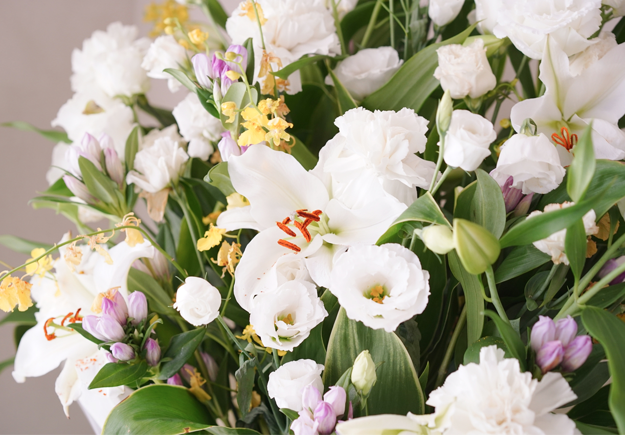 白とピンクと黄色の花々を組み合わせた華やかな生花のアレンジメント
