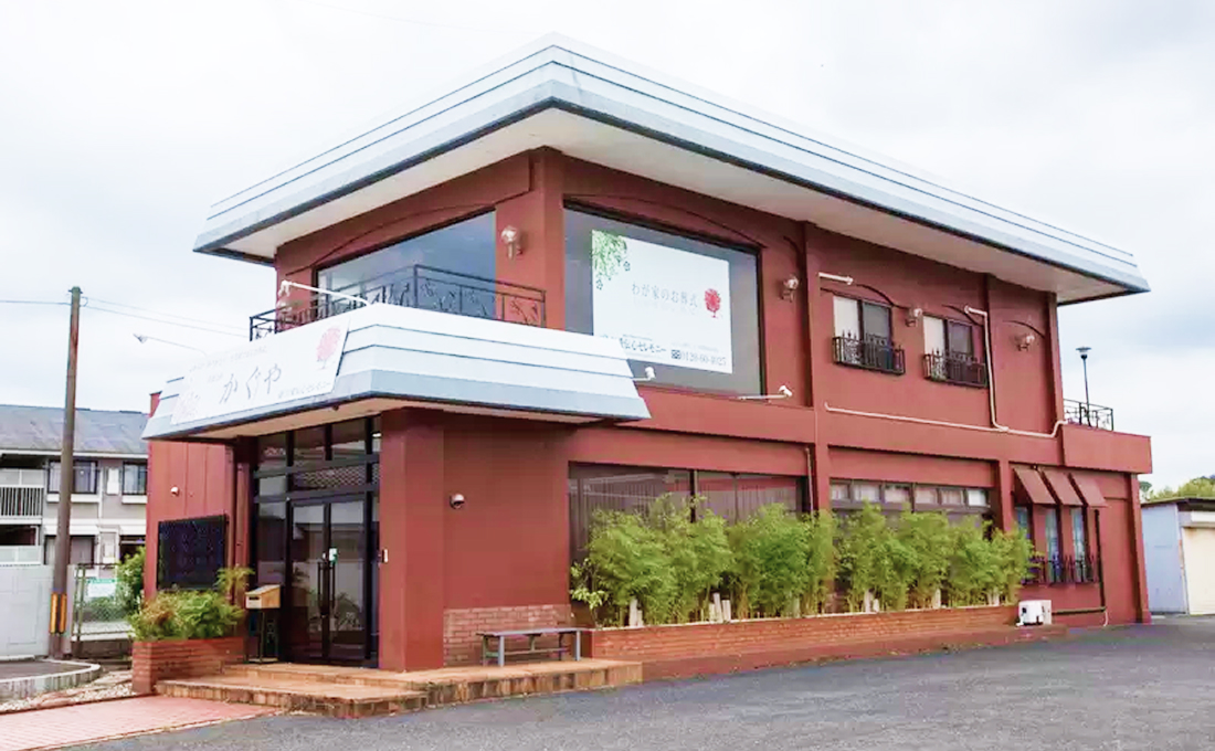 赤茶色の外壁が特徴的な葬儀社の建物外観