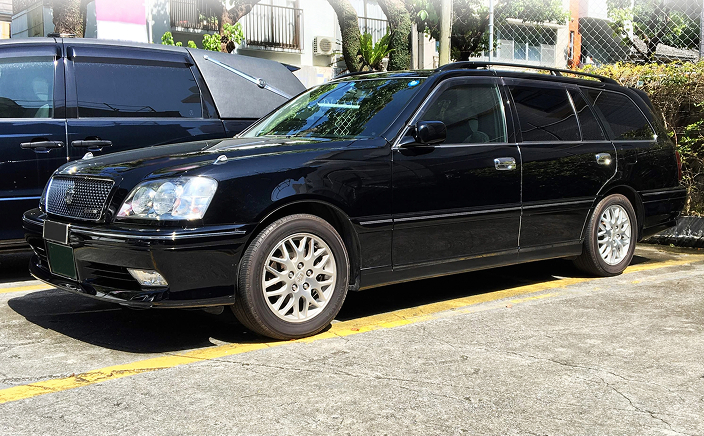 駐車場に停車している黒い葬儀用寝台車