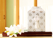 仏壇に安置された白い布で包まれた位牌と白い花