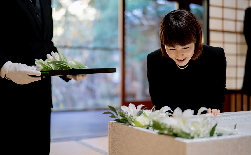 納棺の儀式で白い花を手向ける様子
