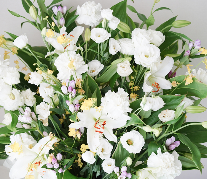 白百合とトルコキキョウを中心とした白い花束のアレンジメント