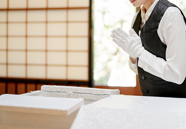 故人に祈りを捧げる喪服姿のスタッフ