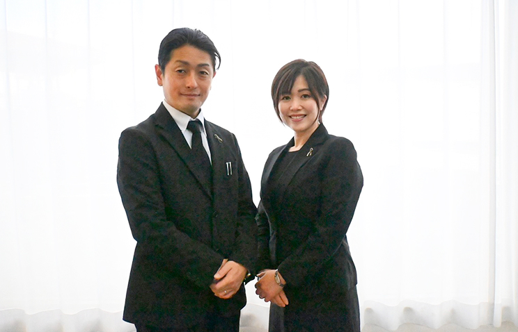 礼服姿で寄り添う葬儀スタッフ夫婦